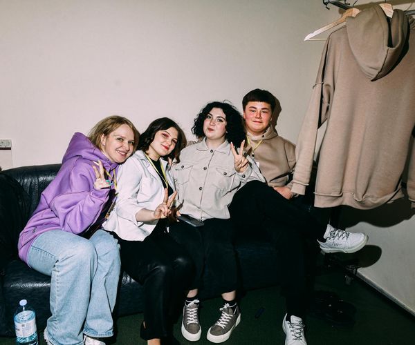 A group of diverse people in comfortable clothing sitting on yoga mats.