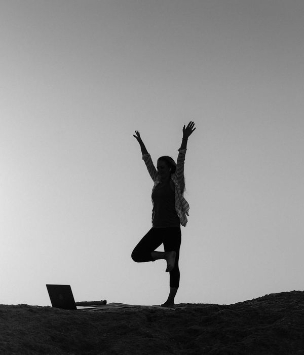 Silhouette of a person stretching peacefully during a sunrise.